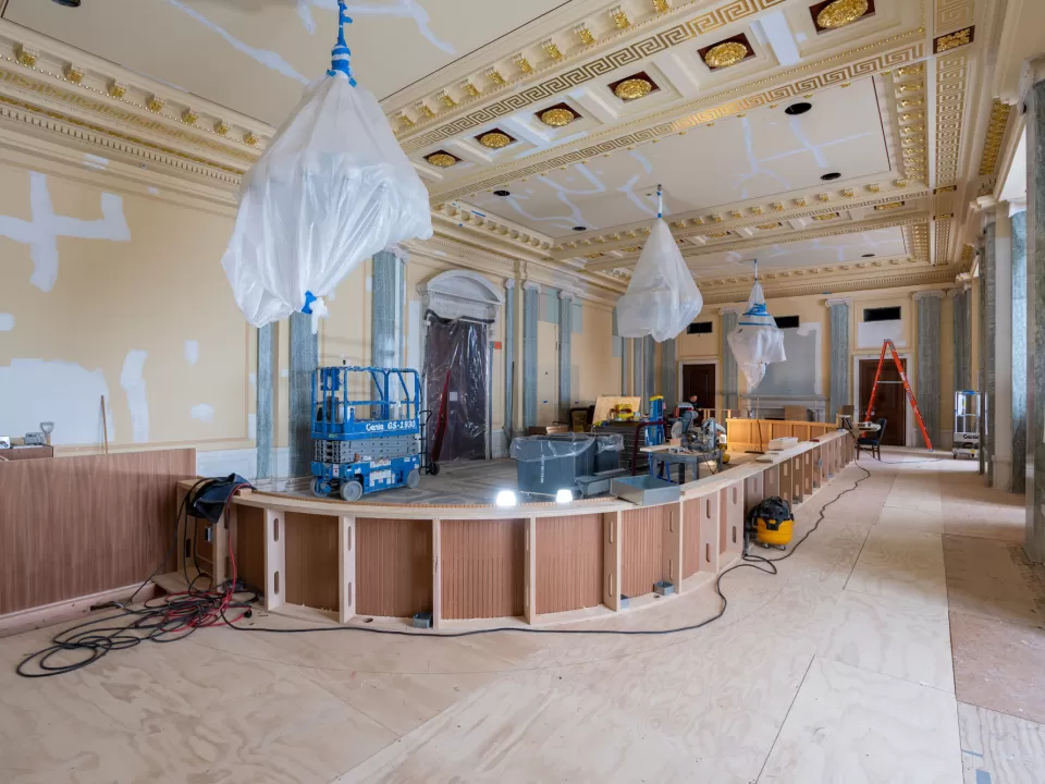 The initial stage of the hearing room renovation, which shows the previous color scheme and the new custom wood dais that has been expanded and rotated 90 degrees to accommodate a larger number of committee members.