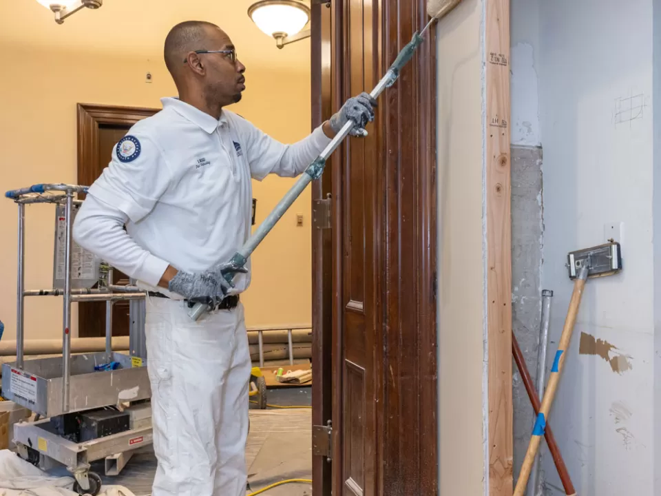 Quincy Biggs, painting worker with the Senate Painting Branch, paints the anteroom’s new wall, which was added to conceal upgraded lighting controls and audiovisual equipment.