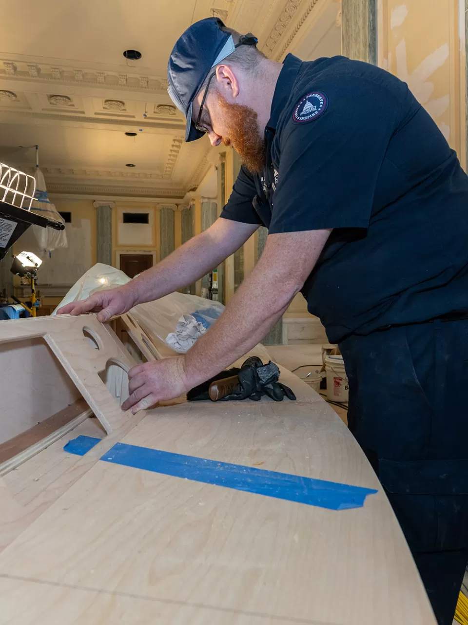Matt Flechner, woodcrafter leader with the Senate Woodcrafting Branch, installs a 14-inch monitor, microphone and touchscreen control panel for each senator into the dais, making sure the equipment doesn't impair the sight line of committee members during hearings.